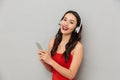 Cheerful young asian woman using mobile phone listening music. Royalty Free Stock Photo