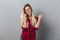 Cheerful young blonde woman talking by phone. Royalty Free Stock Photo