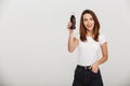 Cheerful young woman holding bottle with soda.