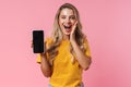 Surprised young woman showing display of mobile phone Royalty Free Stock Photo