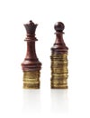 Image of chess pieces standing on stacks of coins isolated on white Royalty Free Stock Photo