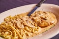 Chicken Marsala with red wine sauce creamy Italian pasta white plate food dish with knife asset Royalty Free Stock Photo