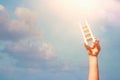 Image of child hand holding a ladder against the sky. education and success concept. Royalty Free Stock Photo