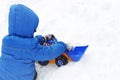 Image of a child sitting on white snow and playing with a toy ex