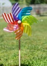 Image of childish colorful pinwheel on the outside. Garden with green grass in a sunny summer day. Rainbow flag LGBT Happy colors