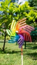Image of childish colorful pinwheel on the outside. Garden with green grass in a sunny summer day. Rainbow flag LGBT Happy colors Royalty Free Stock Photo