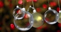 Image of christmas baubles dangling over fairy lights flickering in background