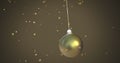 Image of christmas gold bauble over stars falling on brown background Royalty Free Stock Photo