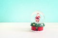 Image of christmas snow glass ball with santa claus in front of pastel blue background Royalty Free Stock Photo