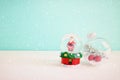 Image of christmas snow glass ball with santa claus in front of pastel blue background Royalty Free Stock Photo