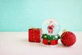 Image of christmas snow glass ball with santa claus in front of pastel blue background Royalty Free Stock Photo