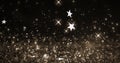 Image of christmas stars falling over glowing brown background Royalty Free Stock Photo