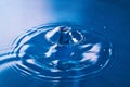 Clean blue water broken by ripples from two water drops hitting in air Royalty Free Stock Photo