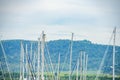 Image close up of boat pole in Marina with docked yachts and moored boats in calm blue sky