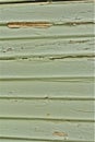 Green paint peeling timber weatherboard wall