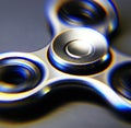 Image of close up of metallic fidget spinner on black background Royalty Free Stock Photo
