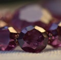 Image of close up of necklace with purple amethyst stones on beige background