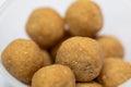 A close-up shot of finely crushed peanut chikki balls on a white background