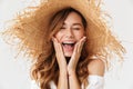 Image closeup of excited woman 20s wearing big straw hat screaming and holding hands at face, isolated over white background Royalty Free Stock Photo