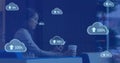 Image of cloud symbols uploading data over asian businesswoman using smartphone at cafe
