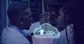 Image of cloud with uploading over african american man working on laptop in server room Royalty Free Stock Photo