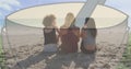 Image of coffee cup against rear view of diverse three women sitting together at the beach Royalty Free Stock Photo