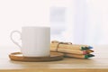 image of coffee cup next to colorful pencils over wooden table. Royalty Free Stock Photo