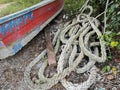 a coil of old nylon rope laying beside the wooden boat. Royalty Free Stock Photo