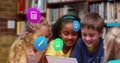 Image of colorful icons over diverse schoolchildren using tablet Royalty Free Stock Photo