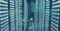 Image of computer language and grid over data server racks Royalty Free Stock Photo