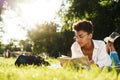 Woman lying outdoors in park on a grass and reading a book Royalty Free Stock Photo