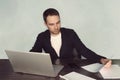 Image concentrated unshaved businessman 30s in white t-shirt holding and looking at clipboard with paper documents during work in Royalty Free Stock Photo