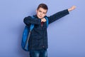 Image of confident joyful young boy raising arms, making gesture, looking directly at camera, getting pleasure from study, Royalty Free Stock Photo