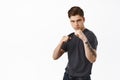Image of confident young man ready for fight, standing in boxing fighter pose, look determined, defending himself Royalty Free Stock Photo
