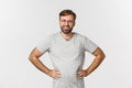 Image of confused bearded man in glasses and gray t-shirt, looking at something strange, frowning perplexed, standing Royalty Free Stock Photo
