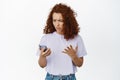 Image of confused redhead woman cant understand how to use application, bad user experience with smartphone app, looking