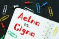 The image contains the inscription Aetna vs. Cigna on a notepad sheet Royalty Free Stock Photo