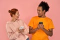 Image of couple African American man and ginger caucasian woman smiling while both using mobile phones isolated over Royalty Free Stock Photo