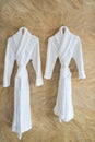 The image of couple white bathrobes on a hanger in bathroom.