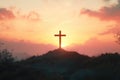 Image of a cross standing tall on the top of a hill as the sun sets in the background Royalty Free Stock Photo