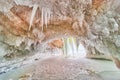 Crystal ice cavern on frozen lake covered in icicles