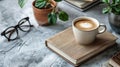 The image of a cup of coffee, a notebook, and glasses on a concrete tabletop is a serene and inviting sight Royalty Free Stock Photo