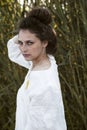 Image of a curly girl with speckle dressed in a white dress, on a field background.