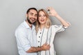 Image of cute couple in casual clothing hugging while blonde woman holding key Royalty Free Stock Photo
