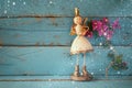 Image of cute fairy princess on wooden table. vintage filtered with glitter overlay