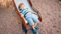 Photo of cute 3 years old toddler boy climbing and riding on big slide on children playground at park Royalty Free Stock Photo