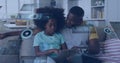 Image of data over happy african american father and daughter using tablet relaxing at home Royalty Free Stock Photo