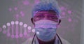 Image of data processing and dna strand over biracial male doctor wearing face mask Royalty Free Stock Photo