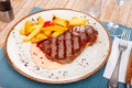 Image of a grilled beef steak and fried potatoes. Royalty Free Stock Photo