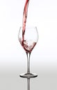 Image of delicious red wine pouring into glass isolated over gray background Royalty Free Stock Photo